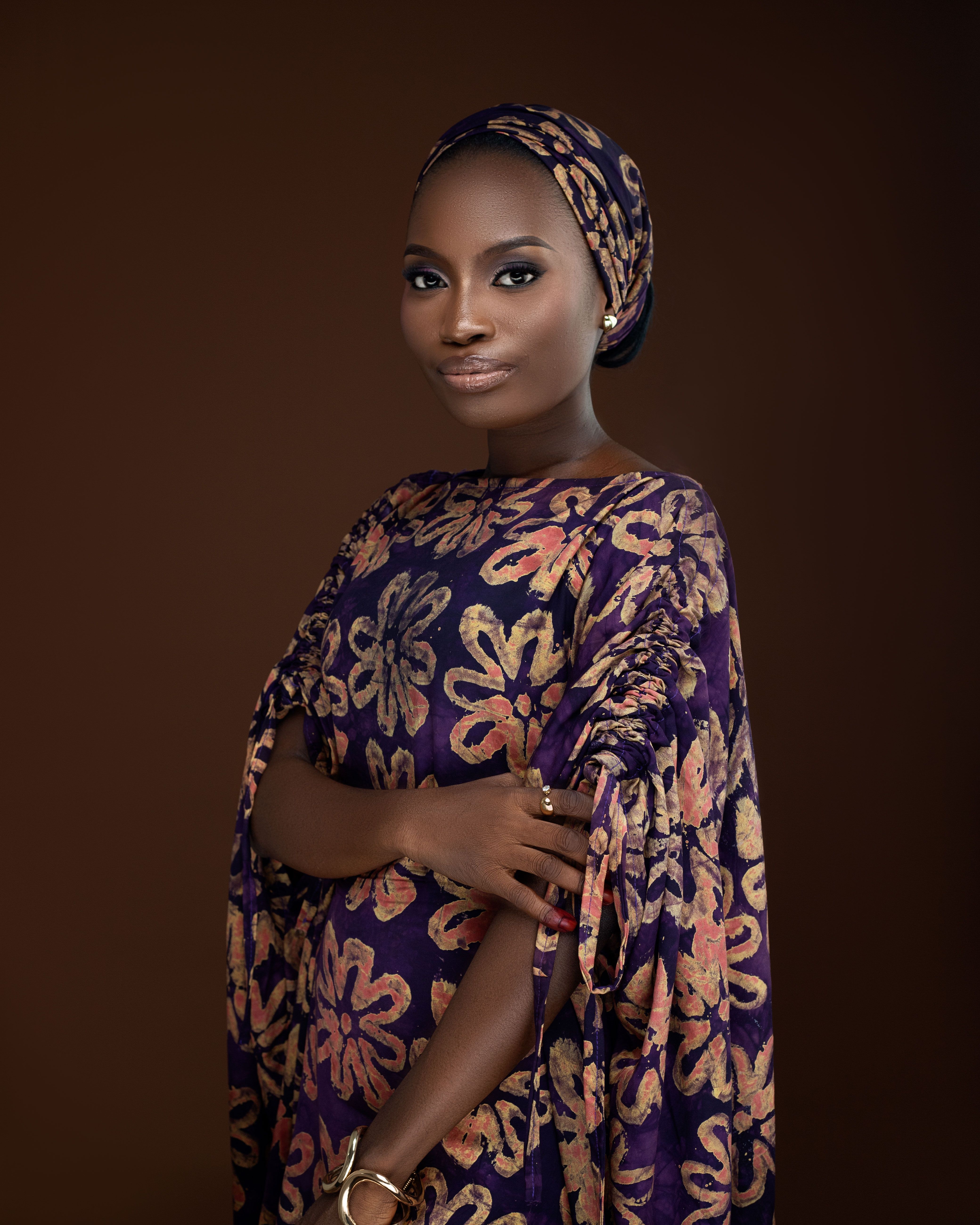 Graceful portrait of a woman in vibrant African traditional clothing, exuding elegance.