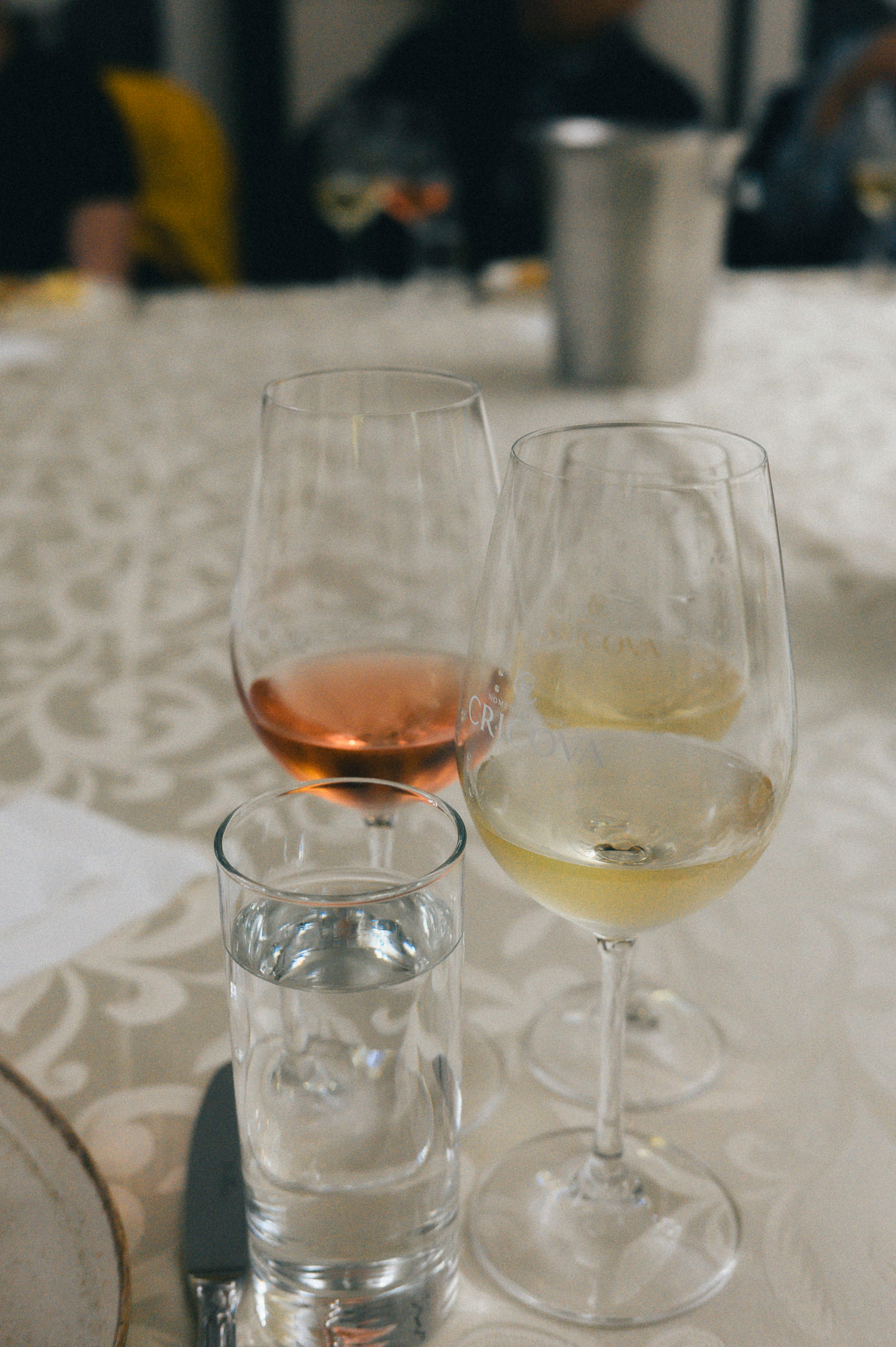 A close-up of a wine tasting setup with red and white wines and water on an elegant table.