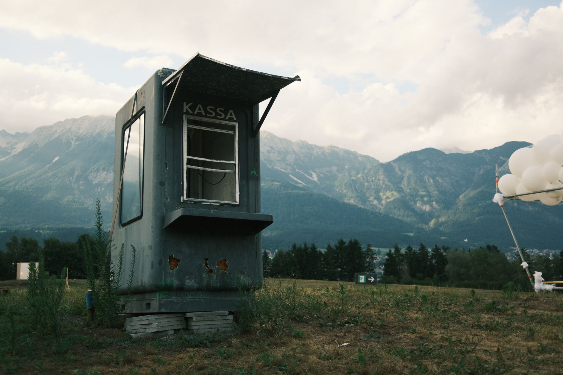 Abandoned ticket booth against the stunning backdrop of Innsbruck's mountains.
