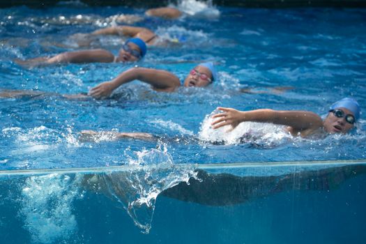 Energetic swimmers race through the pool, showcasing dynamic athleticism and competitive spirit.