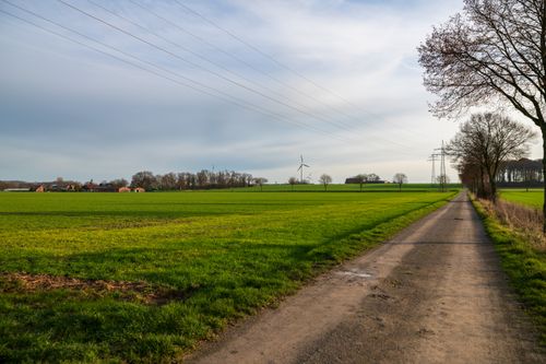 Free Expansive green fields with wind turbines under a clear sky, showcasing sustainable countryside energy. Stock Photo
