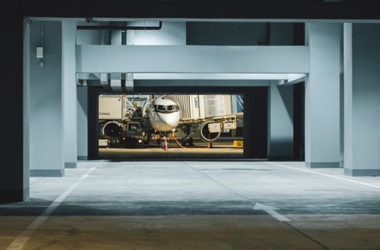Airplane parked at night in a modern airport terminal gate in Angola.