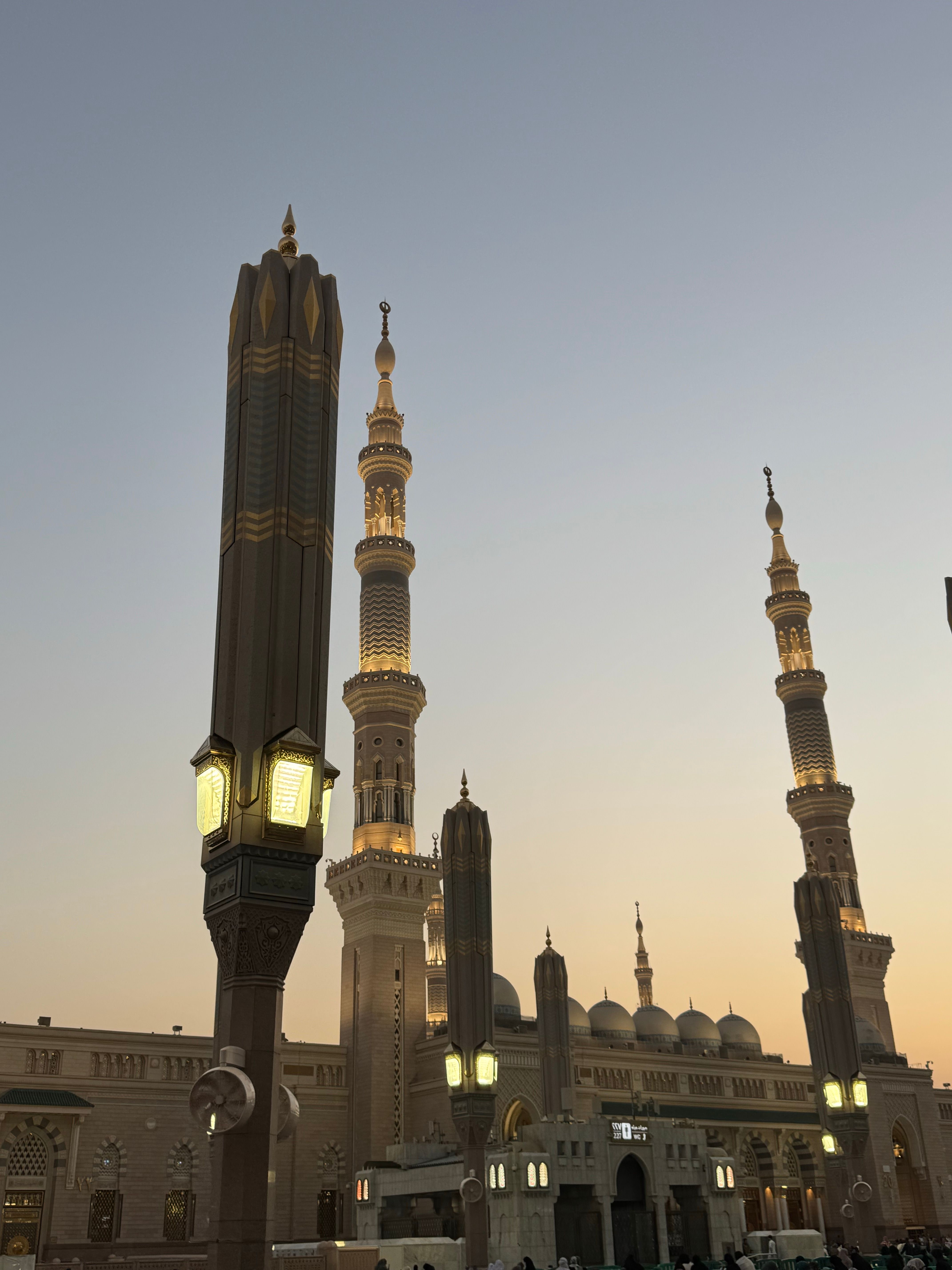 Stunning view of Al-Masjid an-Nabawi's architecture illuminated as evening falls in Medina.