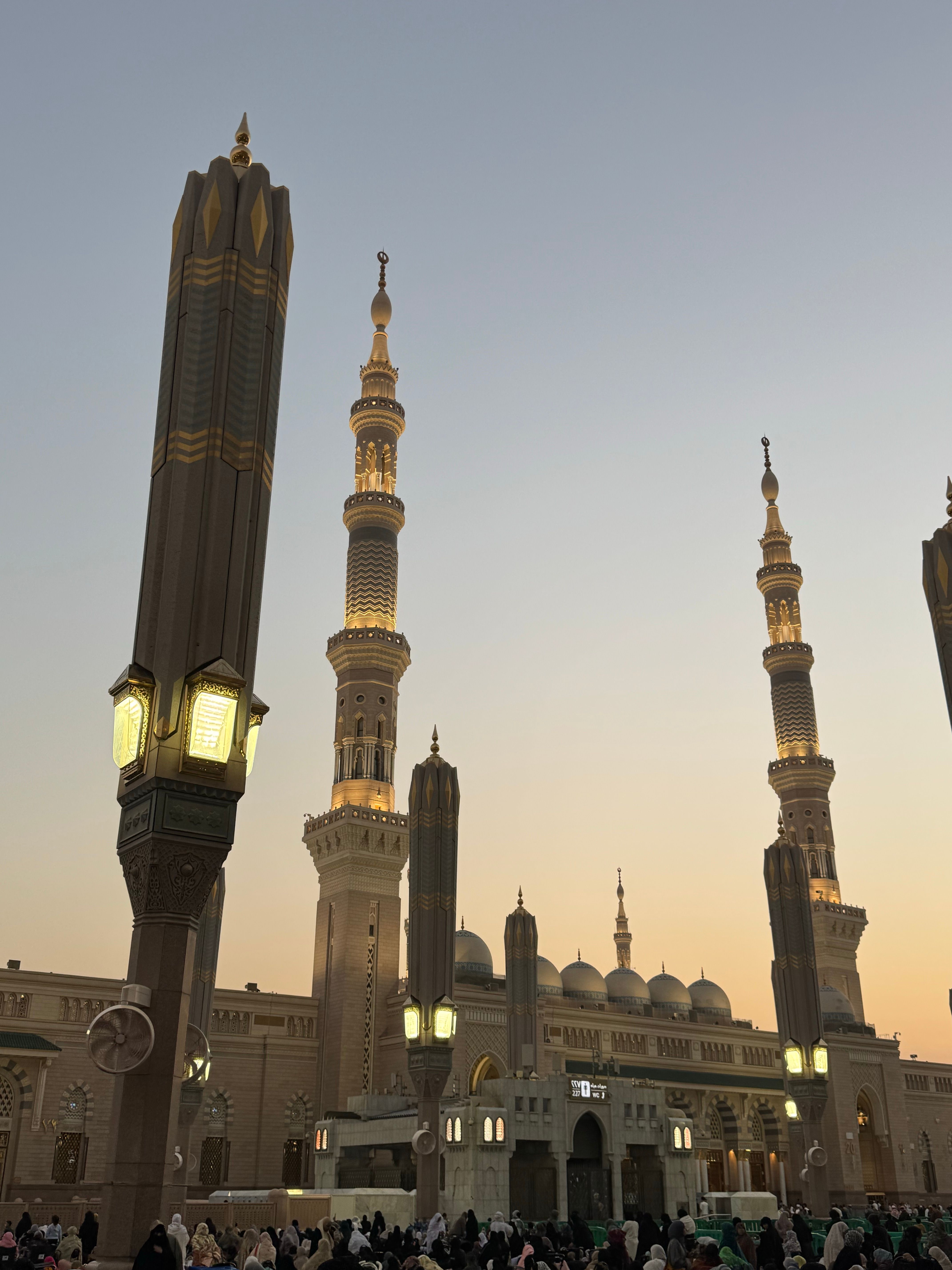 Beautiful sunset at Al-Masjid an-Nabawi, showcasing the mosque's architecture as people gather.