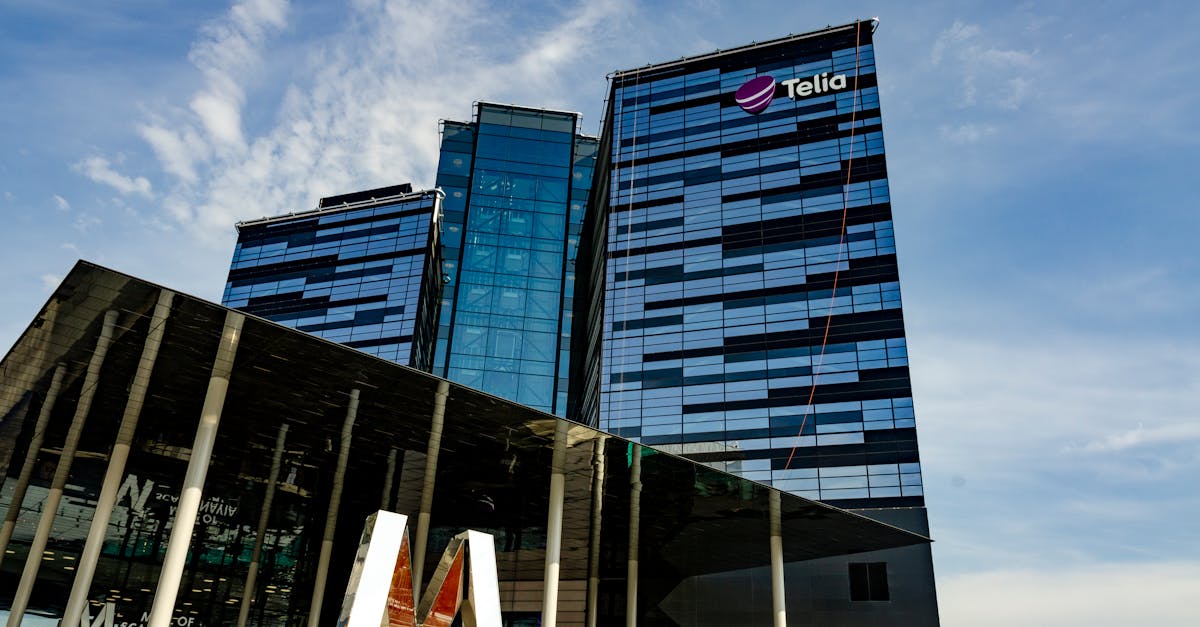 Moderno edificio de oficinas de cristal en Estocolmo con el logotipo de Telia en un día soleado. Moderno edificio de oficinas de cristal en Estocolmo con el logotipo de Telia en un día soleado.