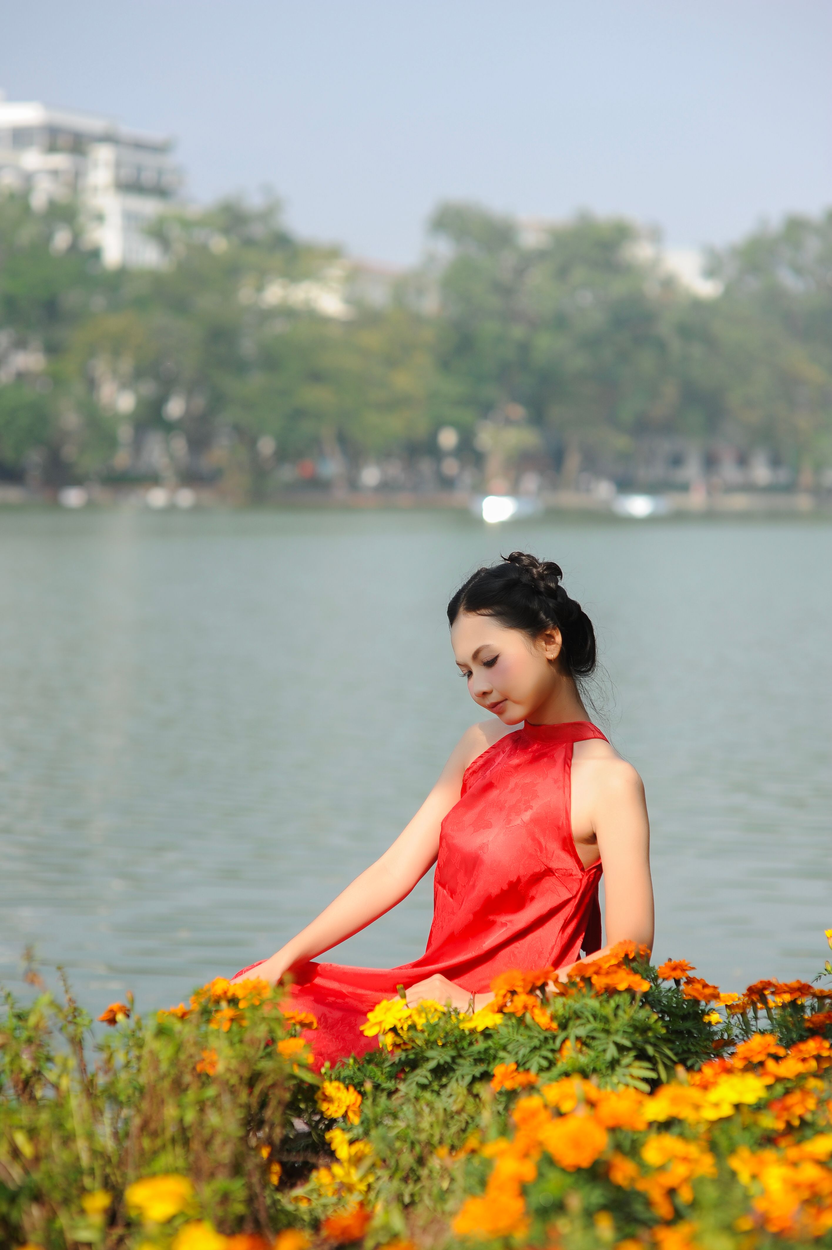 Serene Woman in Red Dress by Lake with Flowers · Free Stock Photo