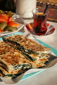 Freshly made gözleme with cheese and spinach, served alongside traditional Turkish tea.