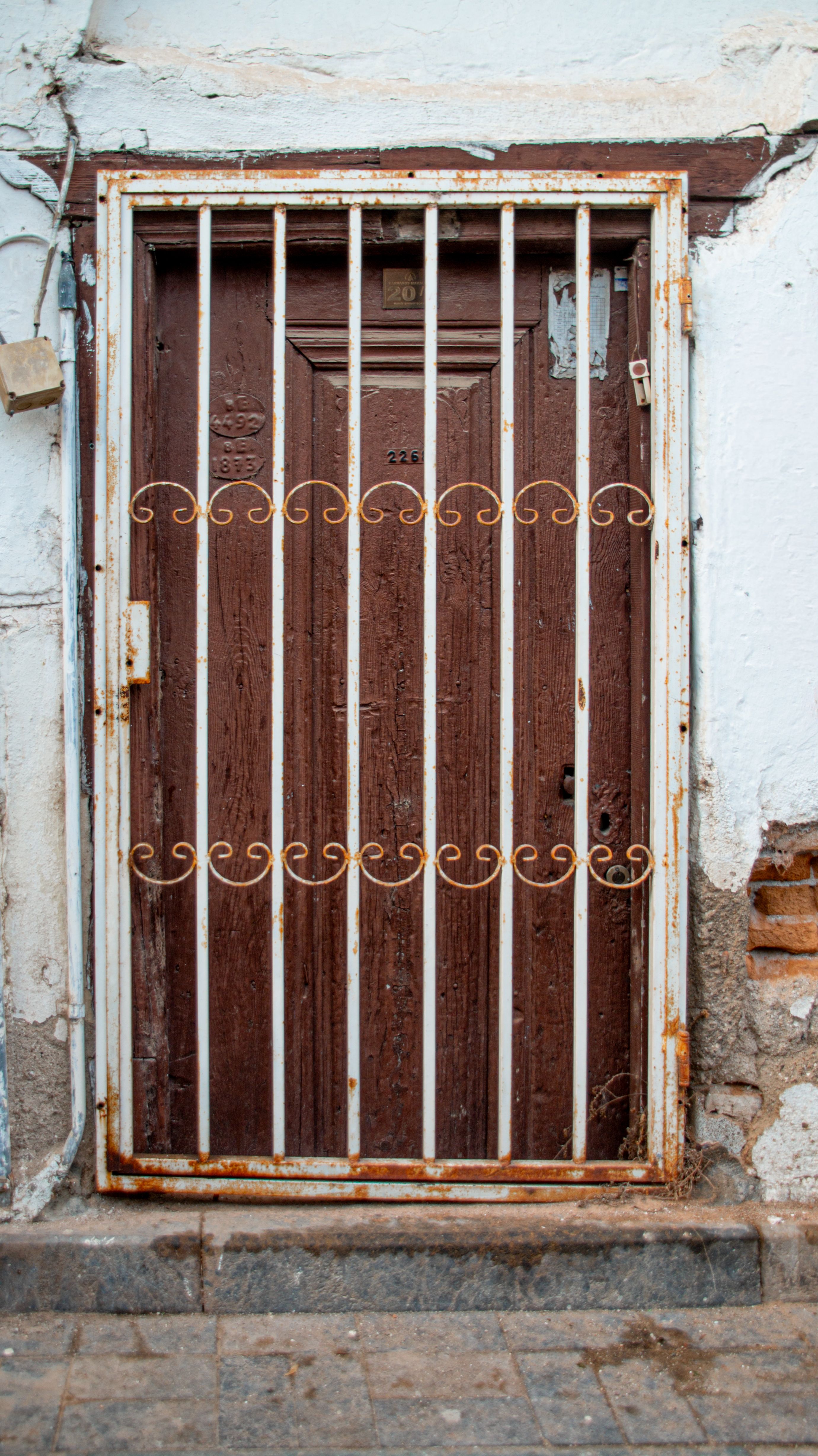 Rustic Wooden Door with Iron Grate in Urban Setting · Free Stock Photo