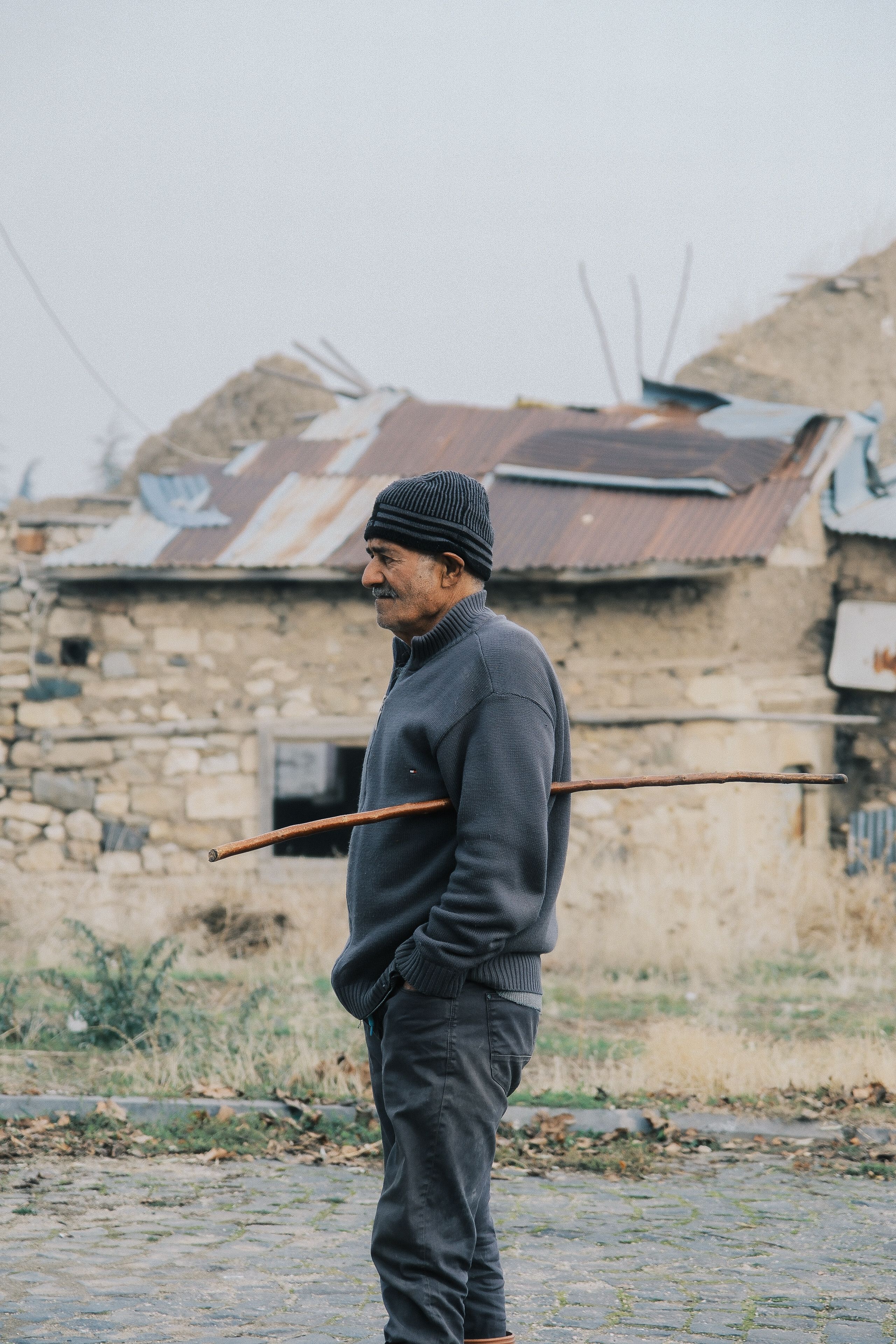 Elderly Man with Walking Stick by Rustic House · Free Stock Photo