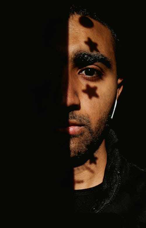 Man With Star and Circle Shadow on Face Wearing Black Crew Neck Shirt