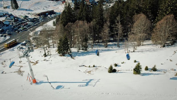 Aerial shot of snowy landscape with ski lift in Feldberg, Germany.