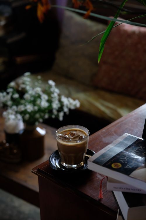Free A warm indoor scene featuring a coffee cup, books, and flowers, exuding relaxation. Stock Photo
