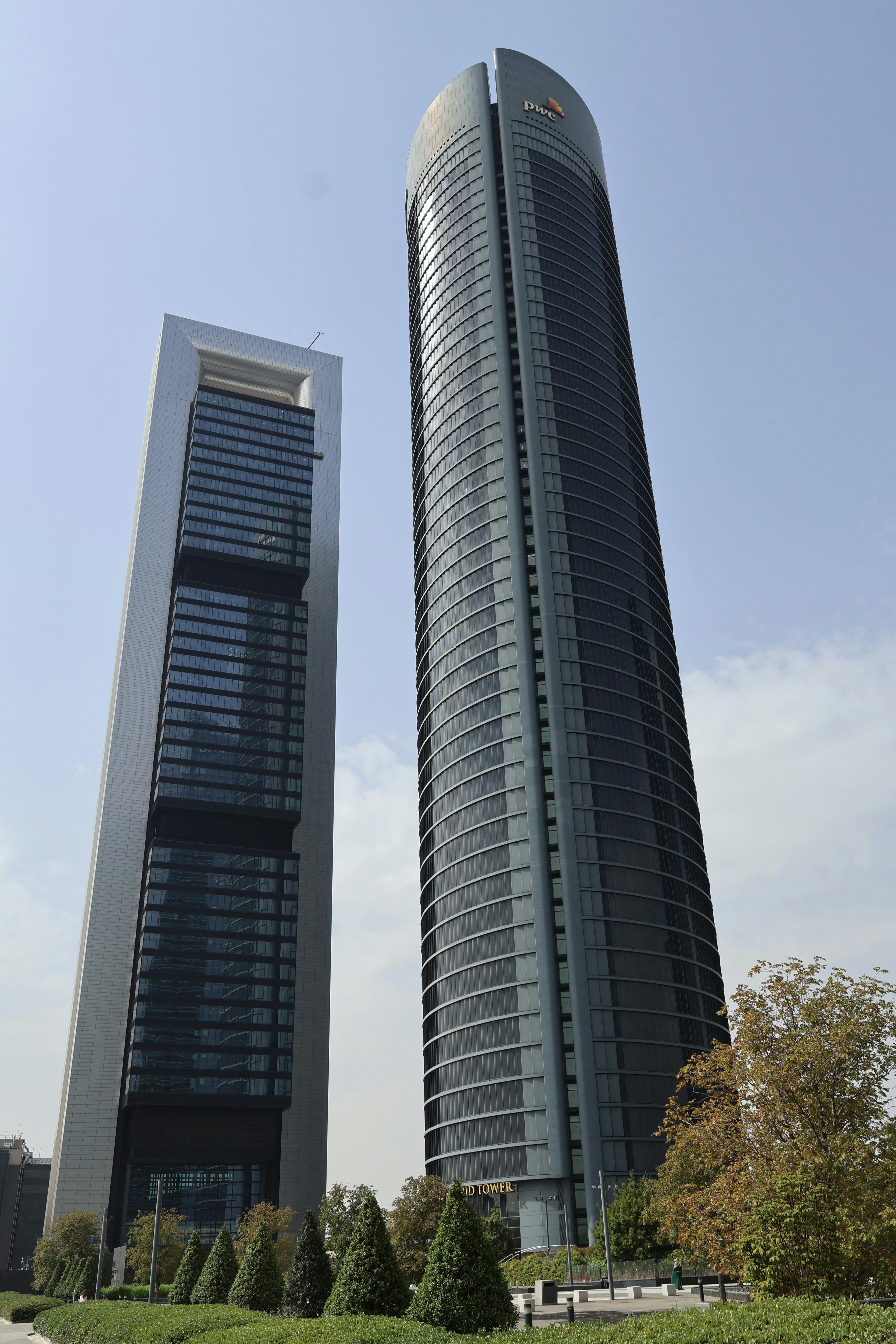 Two iconic skyscrapers in Madrid, Spain, with modern architecture and clear sky.