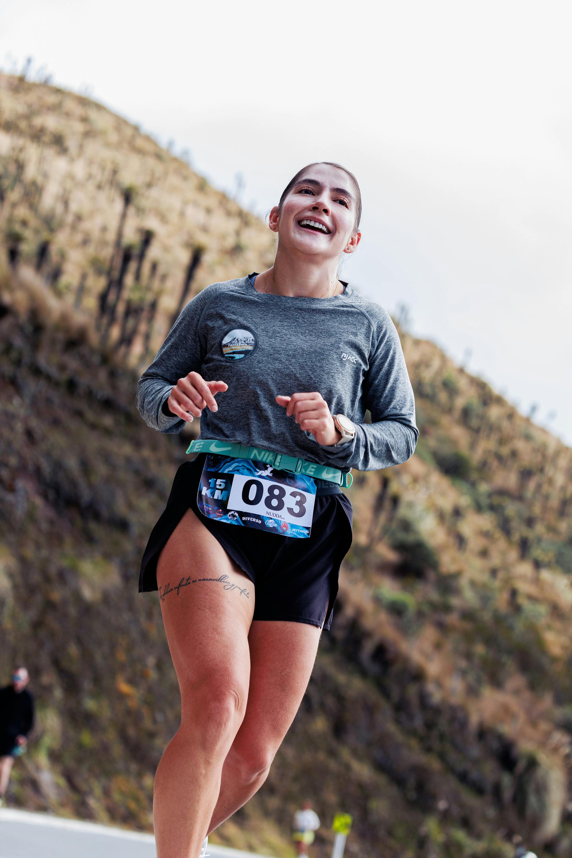 Smiling woman running in a marathon, demonstrating endurance and joy.