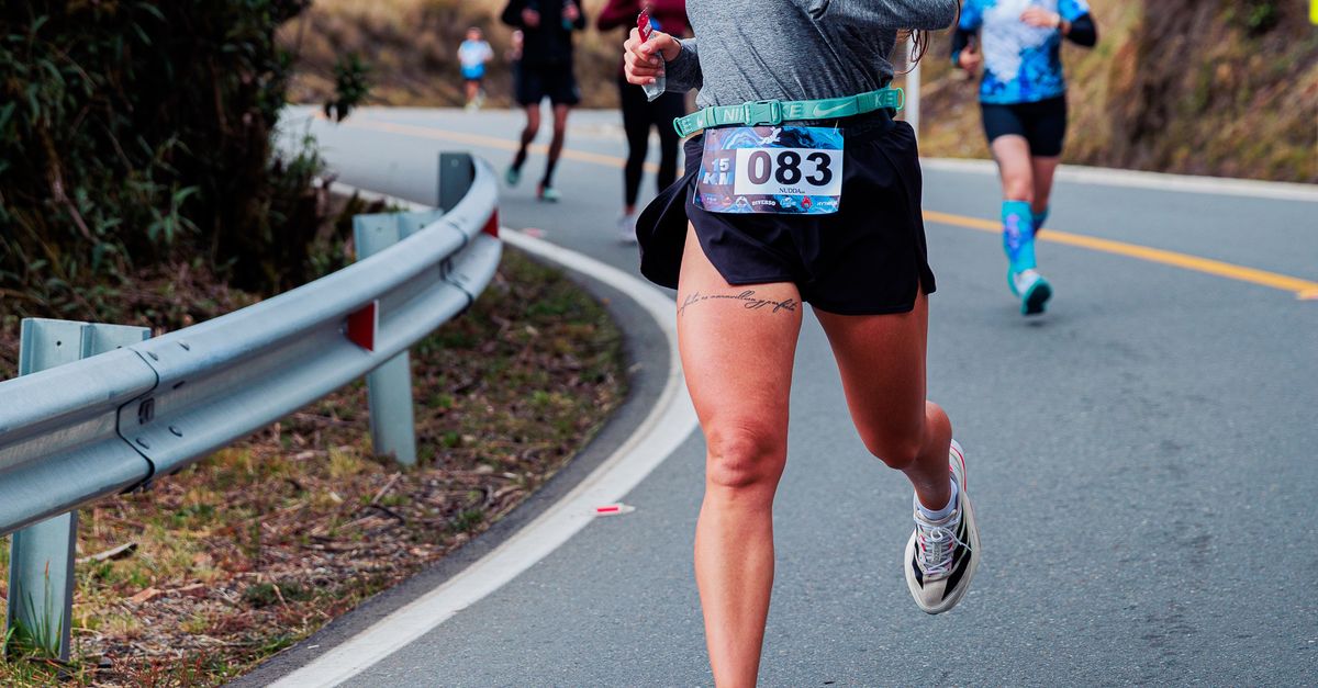 Smiling Runner Smiling Runner in Mountain Road Marathon Race · Free Stock Photo