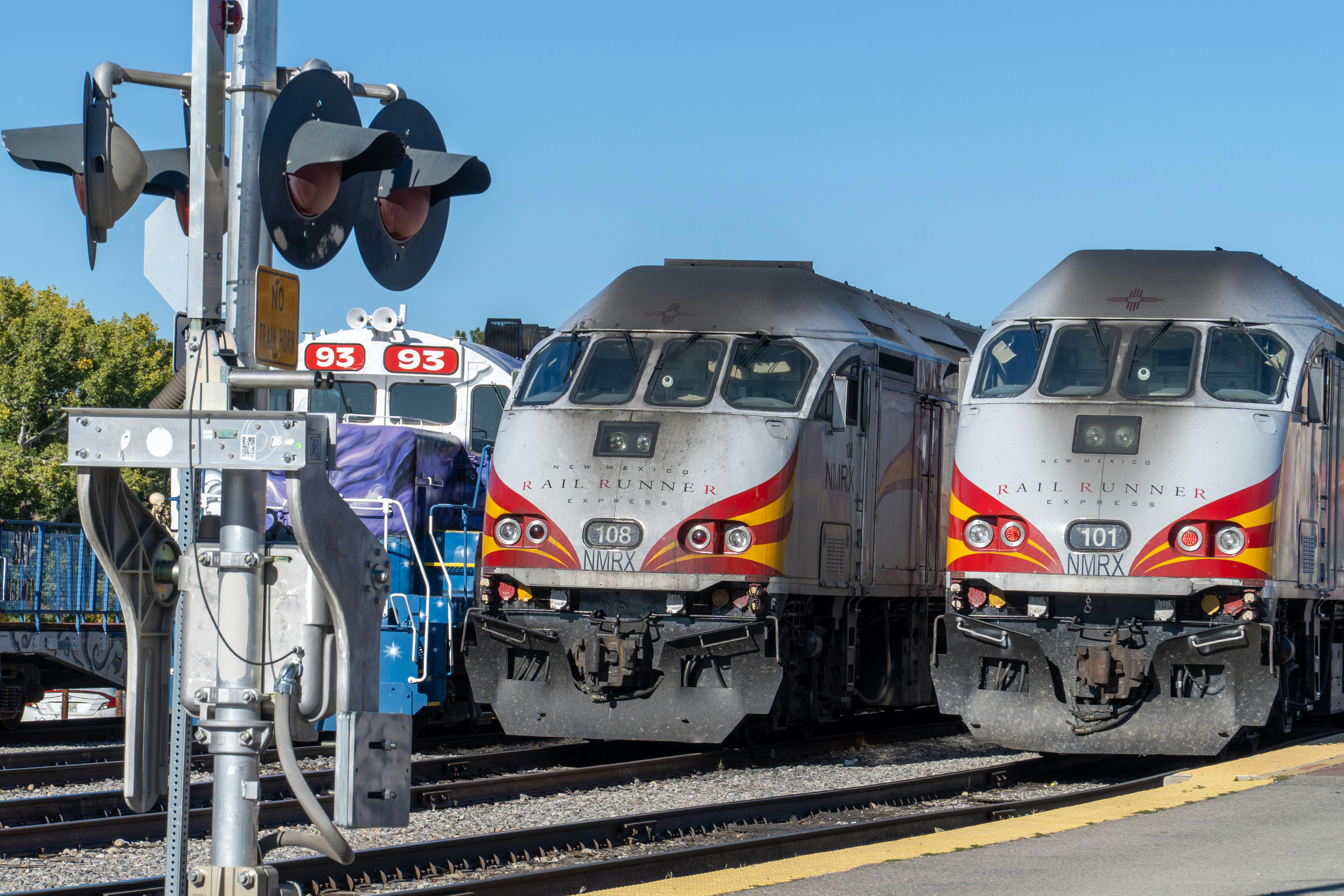 Rail Runner trains parked at Santa Fe train yard on a clear day.