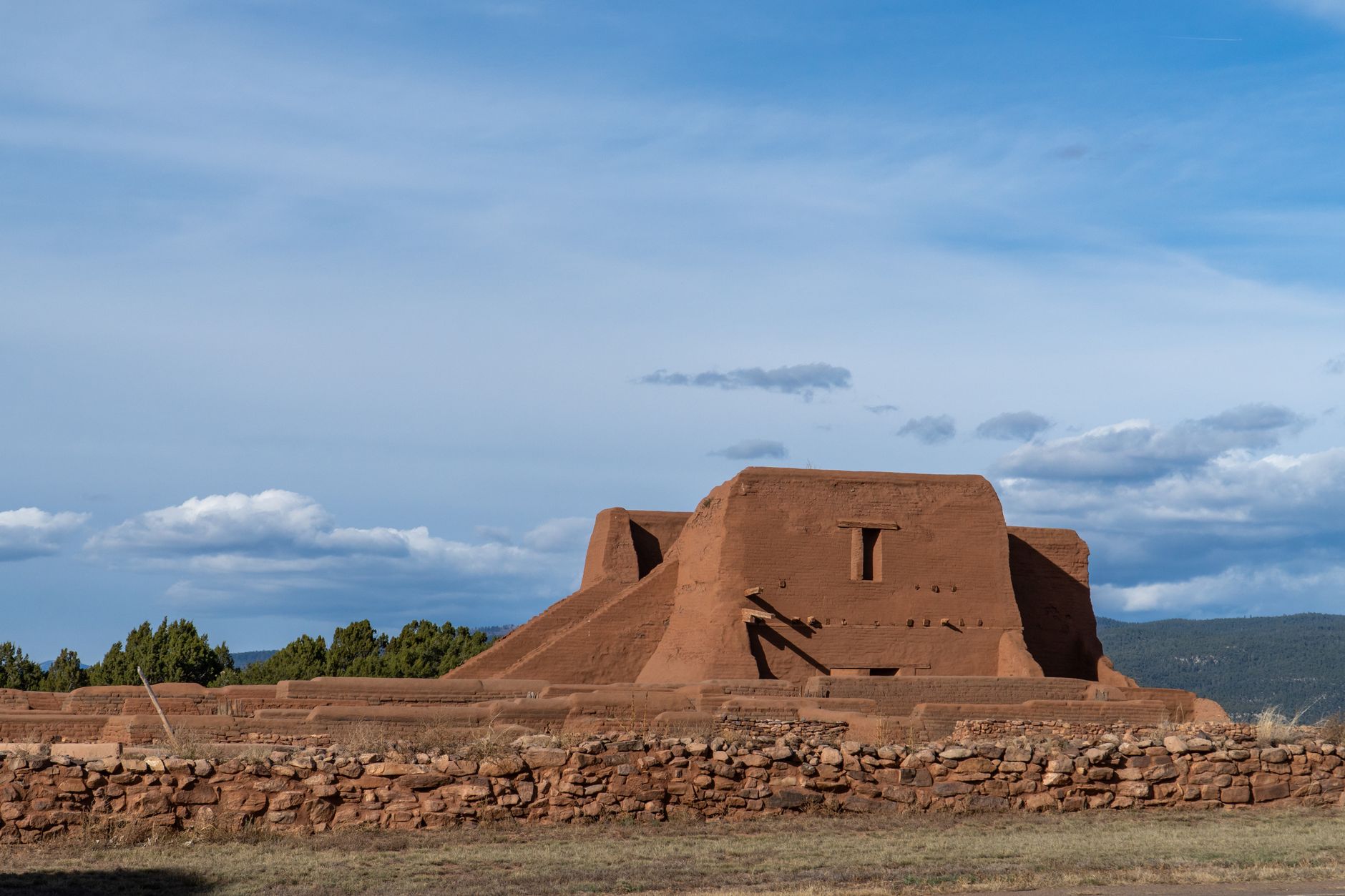 Capture of ancient adobe ruins in Pecos National Historical Park, Santa Fe, with clear sky backdrop.