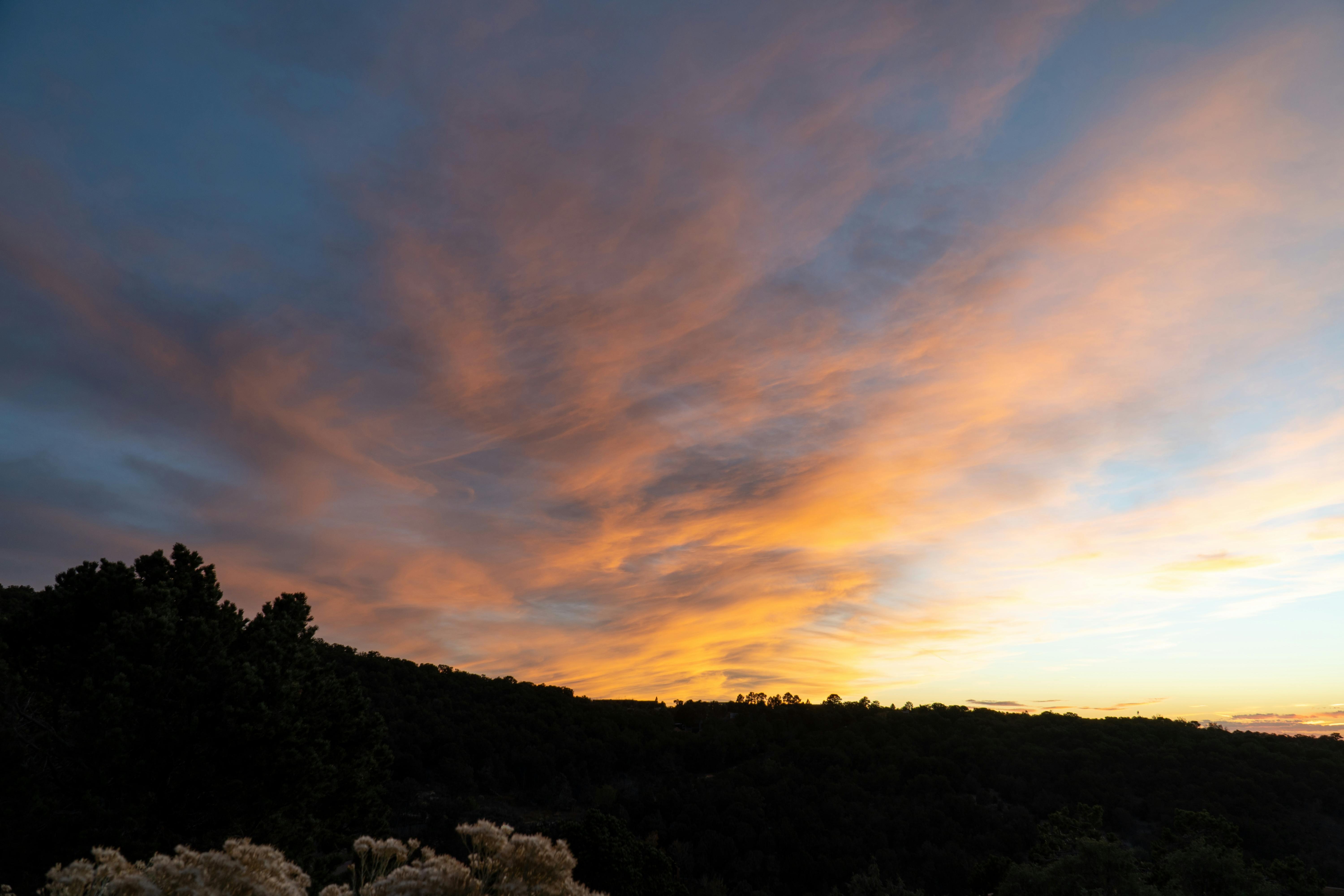 Breathtaking sunset with vivid clouds over the hills of Santa Fe, New Mexico.