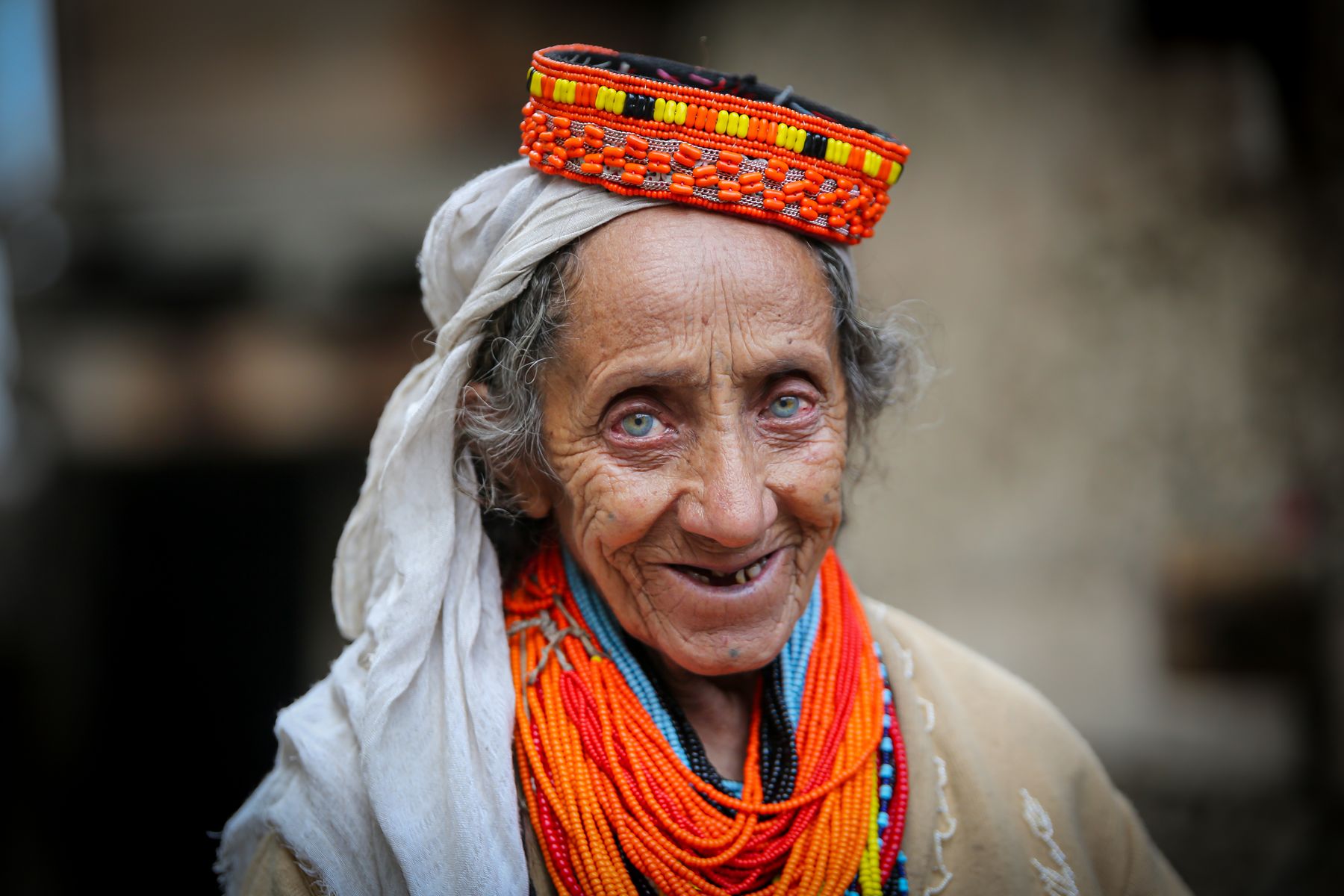 Elderly Kalash woman wearing vibrant traditional attire in Chitral Valley, Pakistan.