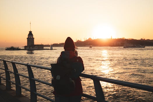 A person gazes at a stunning sunset by the Maiden's Tower in İstanbul, Türkiye.
