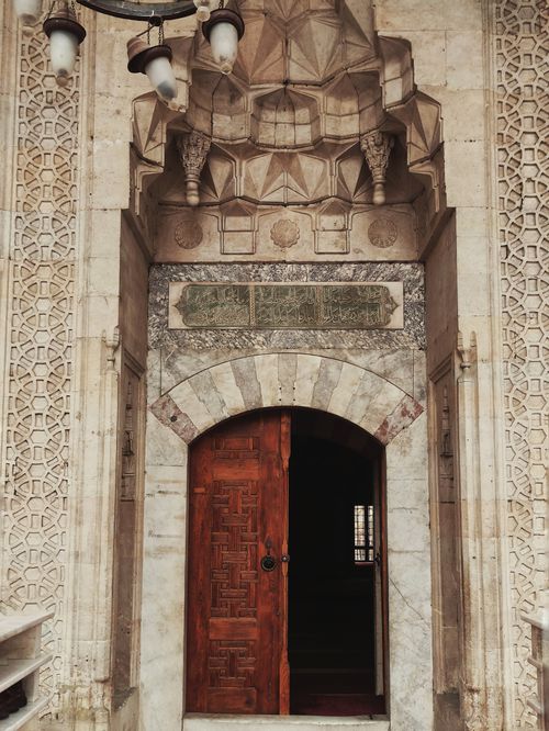 Free Intricate stonework and wooden door of a mosque entrance in Ankara, Türkiye. Stock Photo