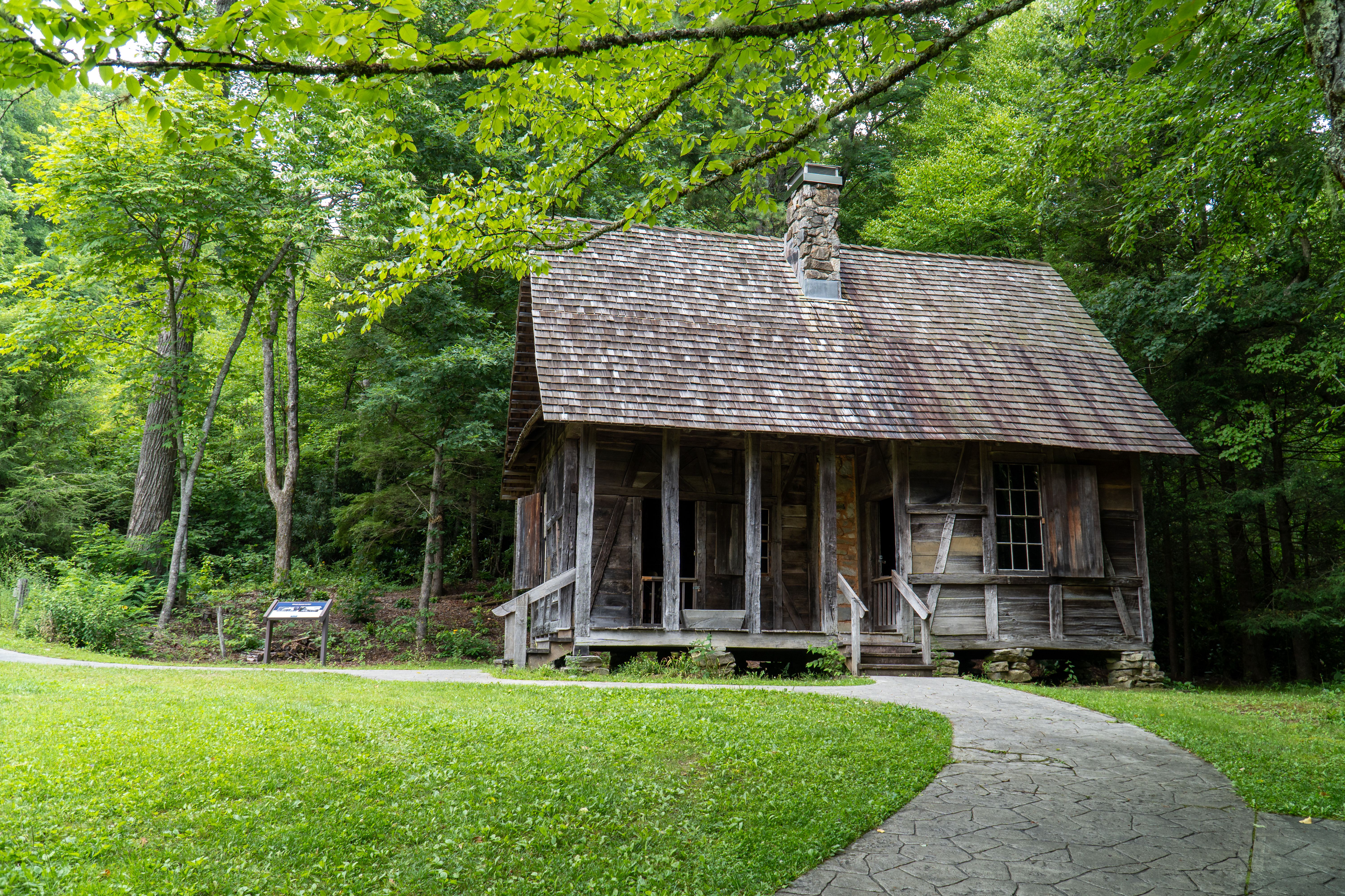 Rustic log cabin nestled in lush green woods, capturing Appalachian heritage