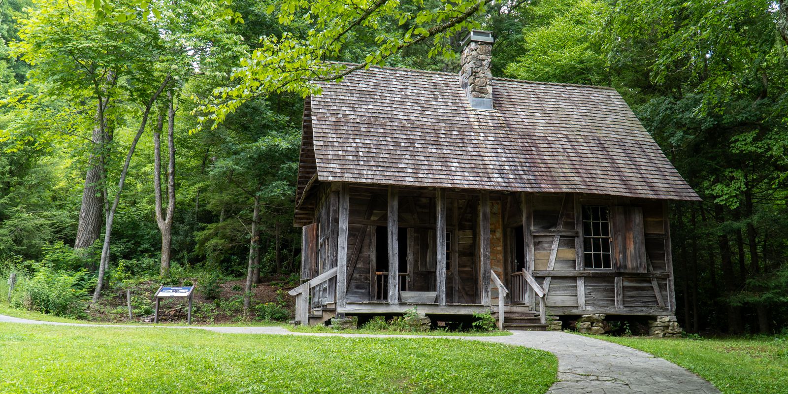 Rustic log cabin nestled in lush green woods, capturing Appalachian heritage