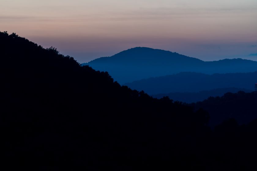 Layered blue ridgelines at dusk near a mountain valley — photo by Ken Jacobsen on Pexels