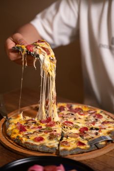 A mouthwatering homemade pizza in Türkiye with cheese pull and delicious toppings.