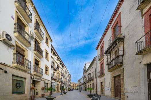 Historic street view in Baeza, Andalucía with traditional architecture under a clear blue sky.