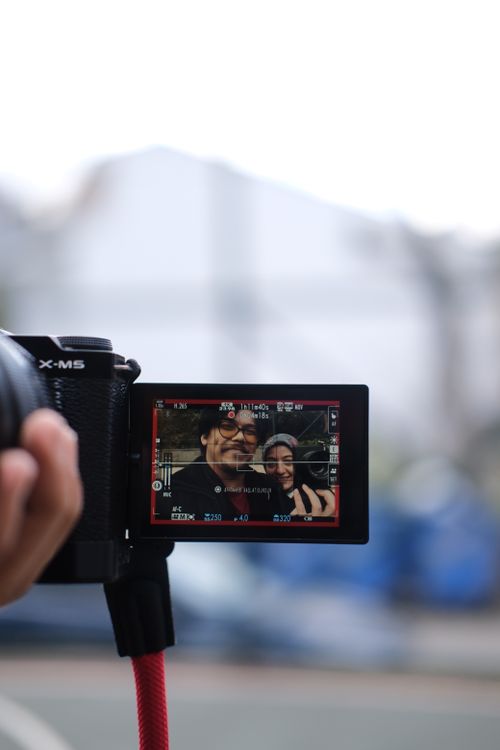 Free Camera focusing on a smiling couple as seen through its display outdoors. Stock Photo
