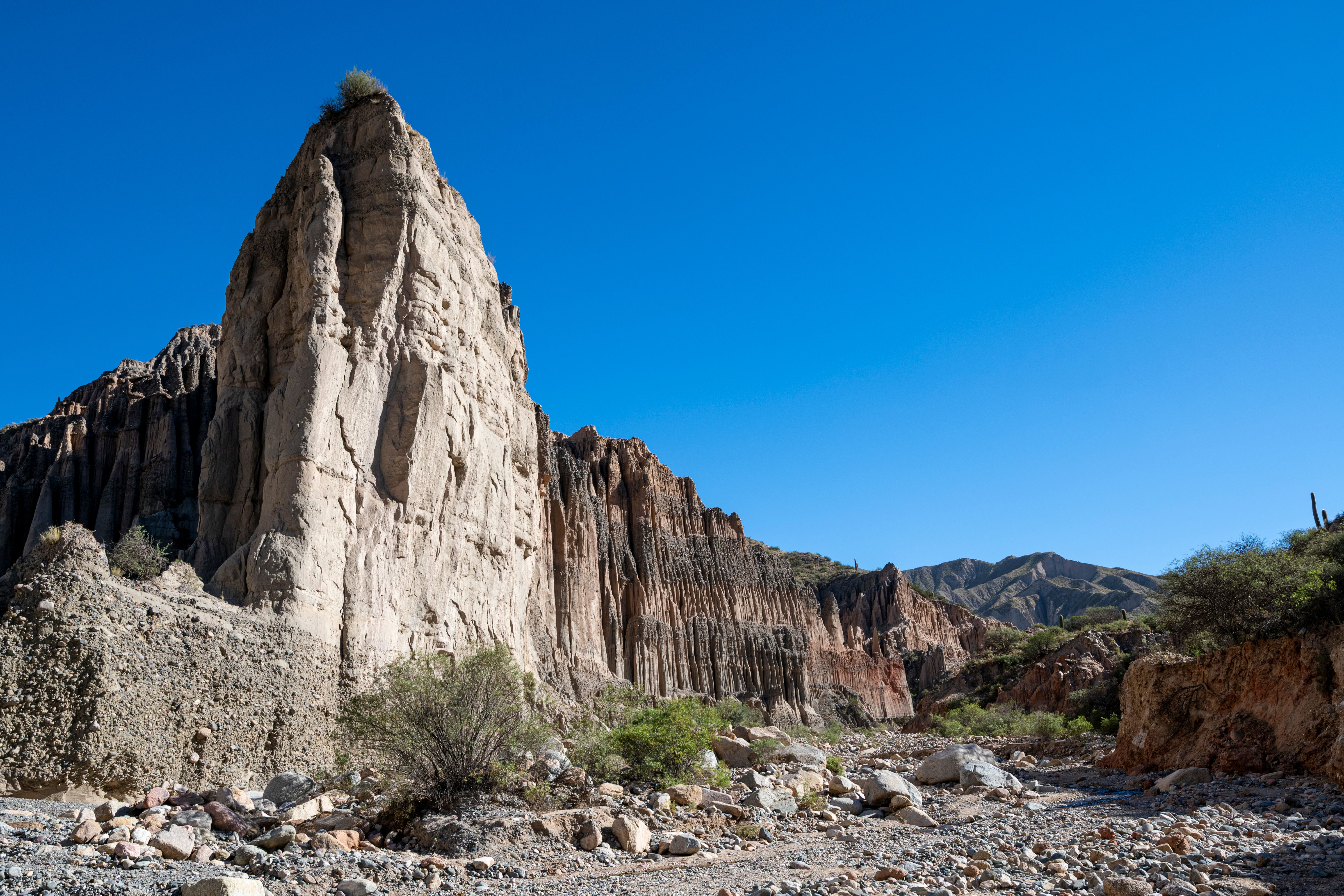 Stunning rock formations in a desert landscape under a vibrant blue sky, showcasing natural geological beauty.