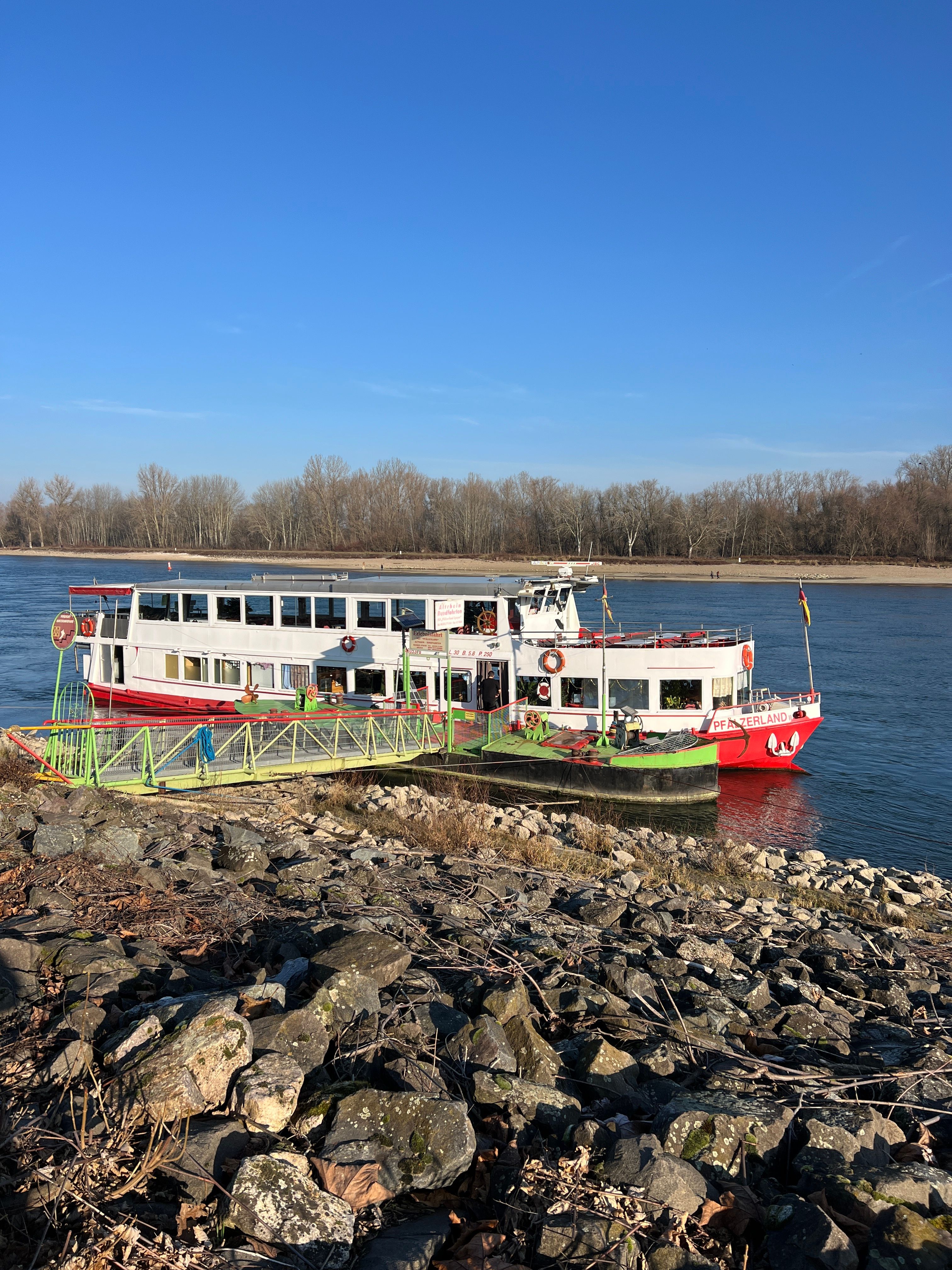 Colorful ferry moored by rocky riverside · Free Stock Photo