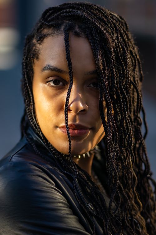 Free Close-up portrait of a woman with braided hair and a leather jacket. Stock Photo