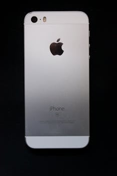 Close-up of an iPhone with Apple logo on a black backdrop, showcasing sleek design.