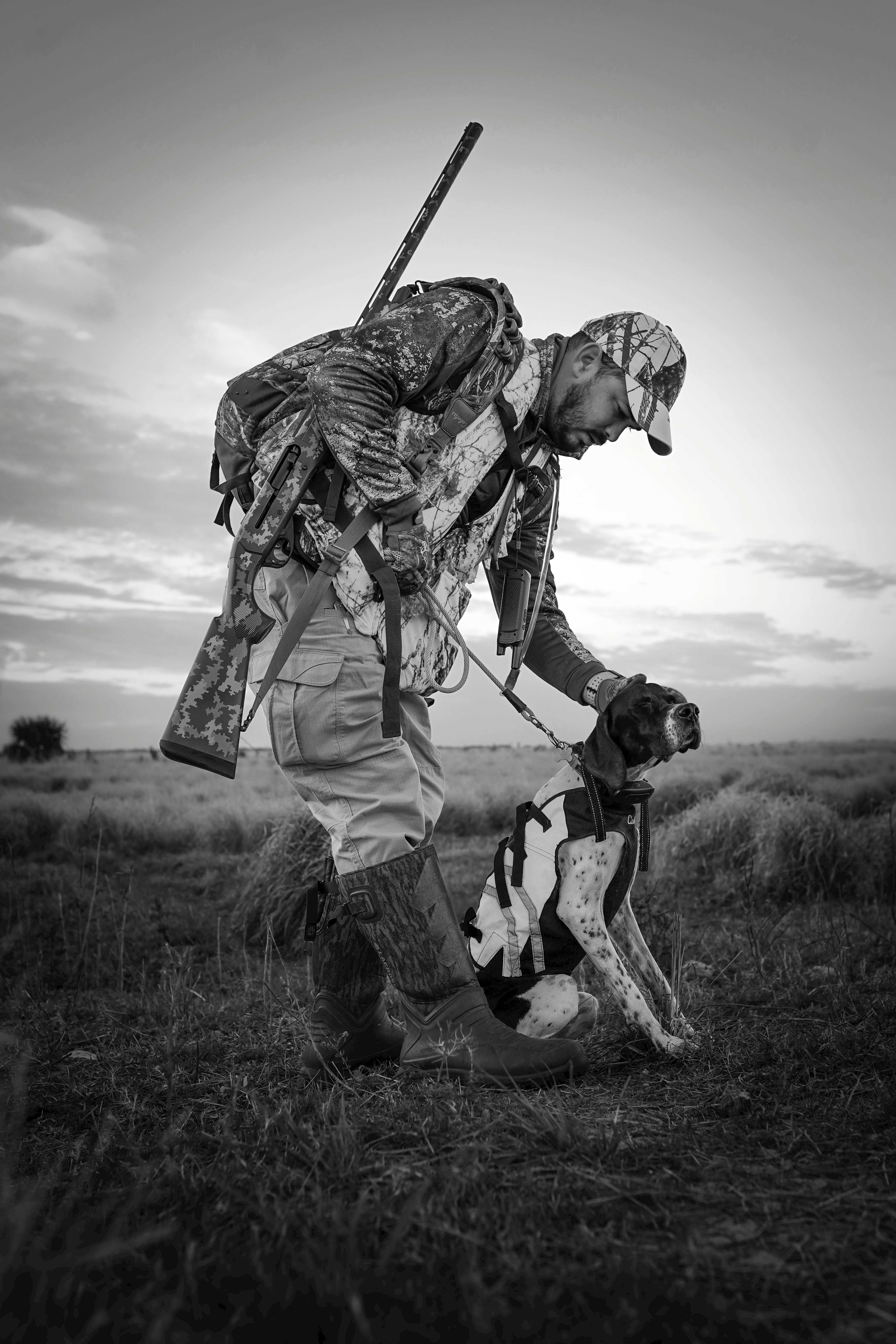 A hunter and his dog in a Florida field at sunrise, ready for the day's adventure.