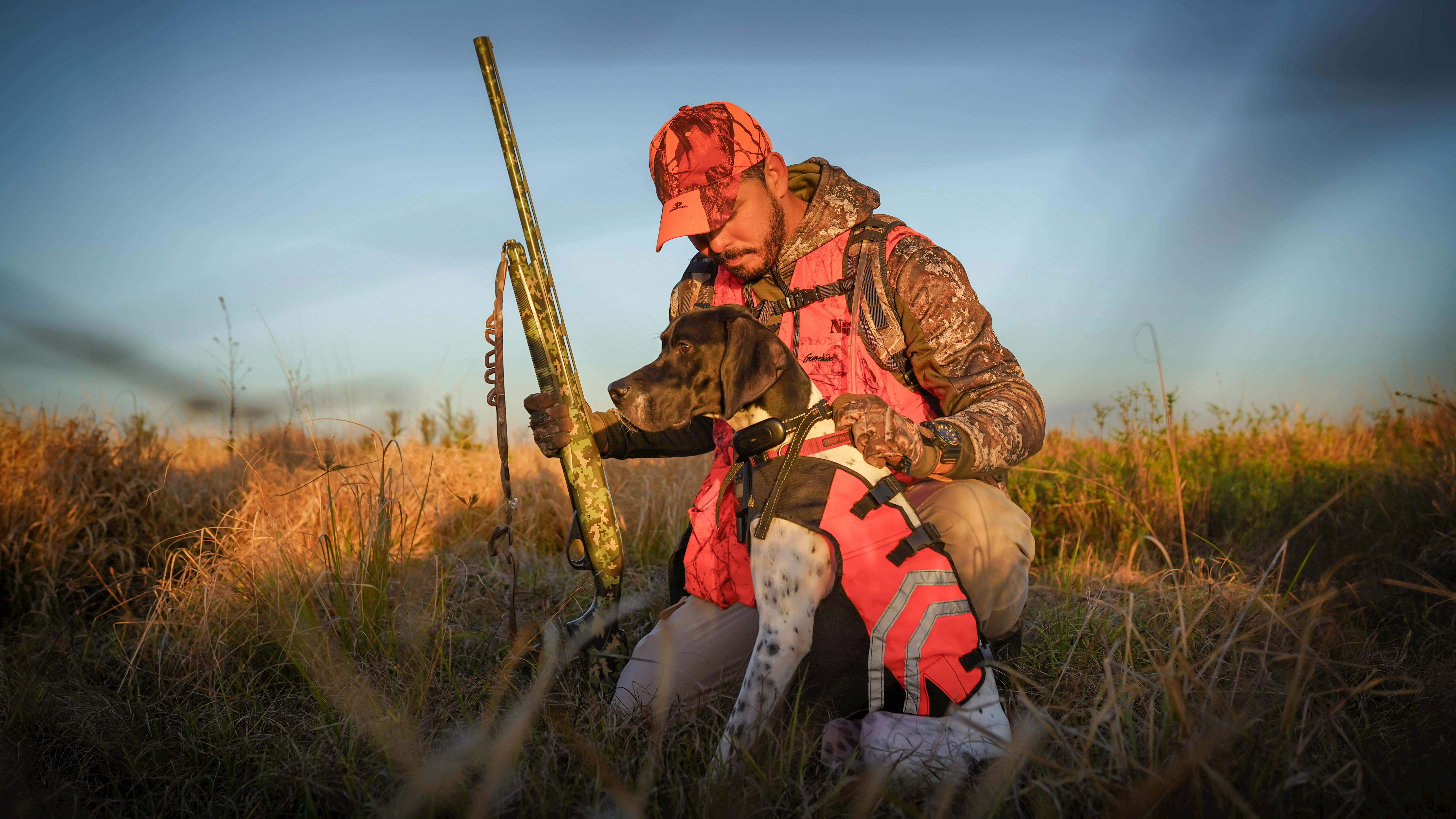 A hunter with his dog in Florida's grasslands during the day.