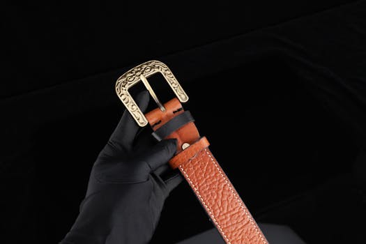 Luxurious brown leather belt featuring an intricately designed brass buckle, perfect for fashion and gift occasions.