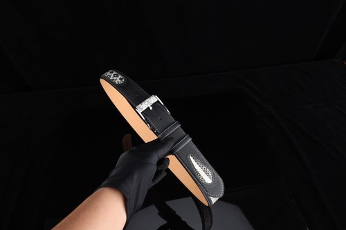 Free Stylish black leather belt held against a black background, showcasing a silver buckle and design details. Stock Photo