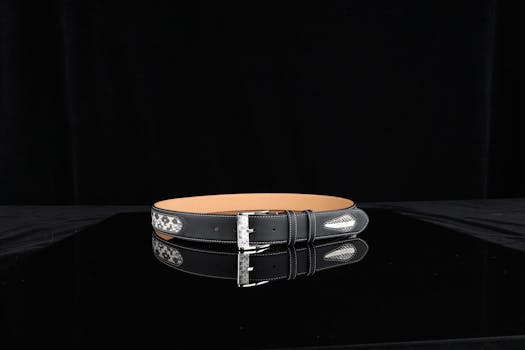 Stylish black leather belt featuring intricate design elements and silver buckle, perfect for fashion accessories.