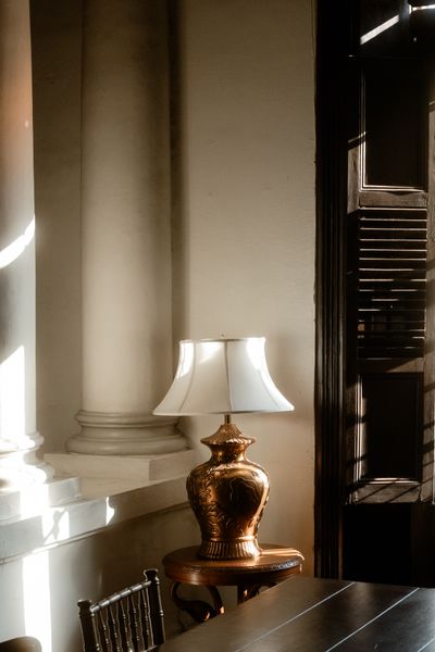Brass table lamp on a round wooden side table — photo by Brunxs on Pexels
