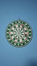 Dartboard with Darts on a Blue Wall