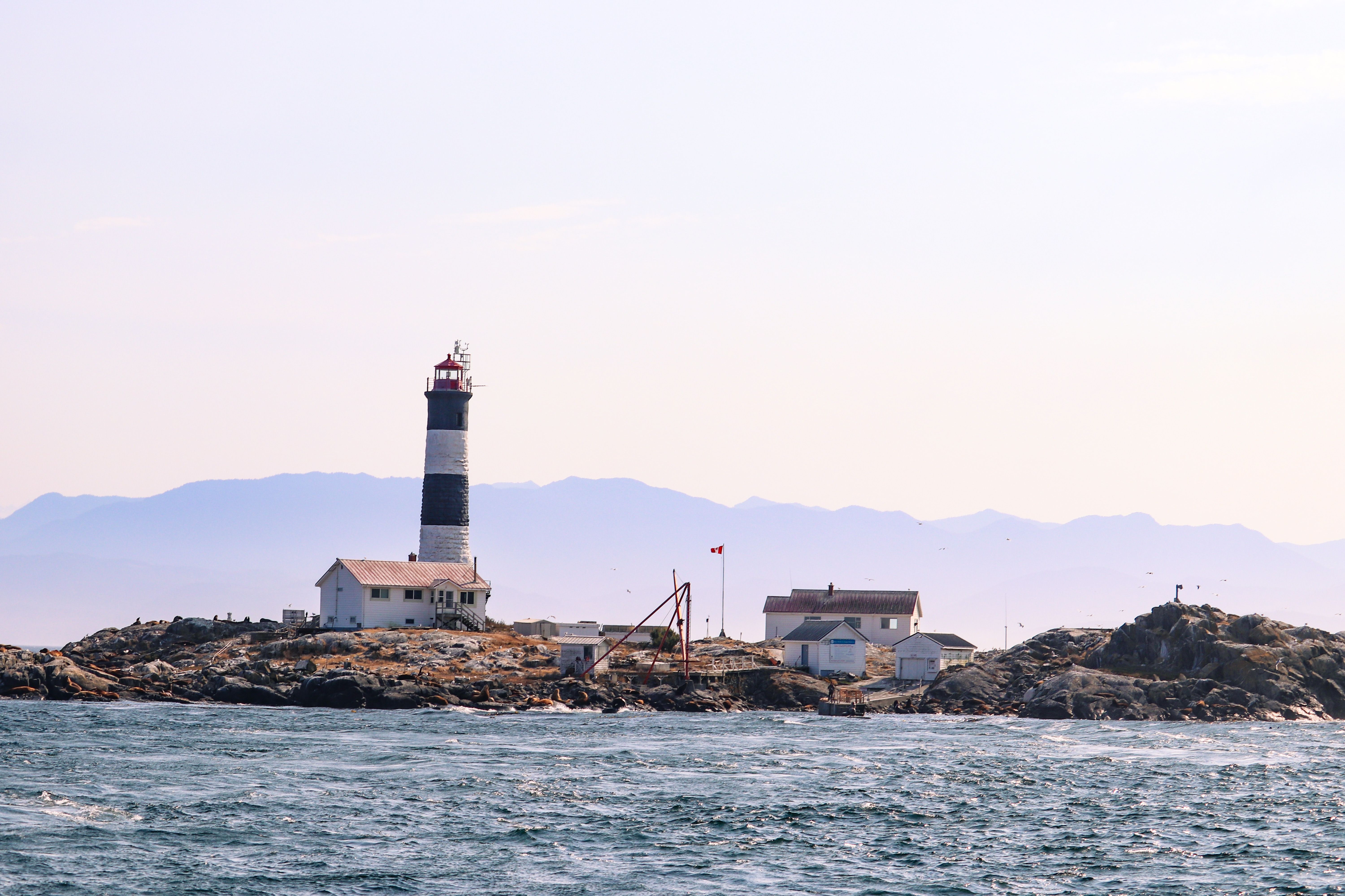 Scenic view of a lighthouse on rocky coast in British Columbia, Canada.
