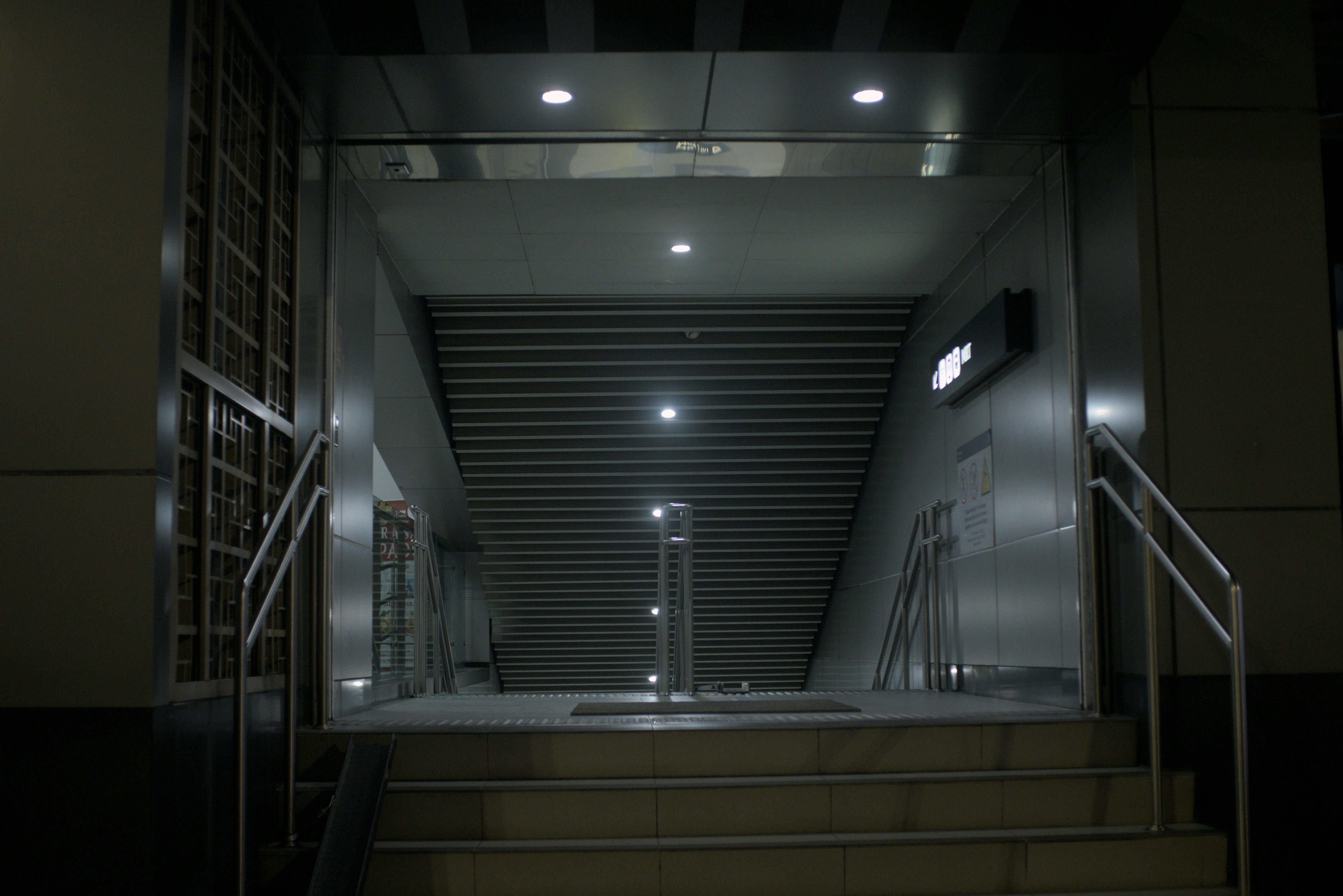 Kostnadsfria En stämningsfull och minimalistisk tunnelbaneentré med en modern trappa, vilket skapar en känsla av ensamhet. Stock foto