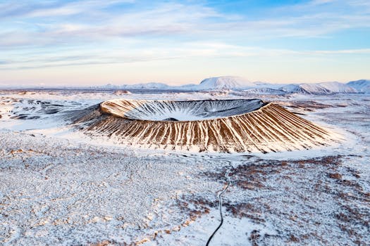 Stunning aerial view of a snow-covered volcanic crater in Þingeyjarsveit, Iceland during winter.