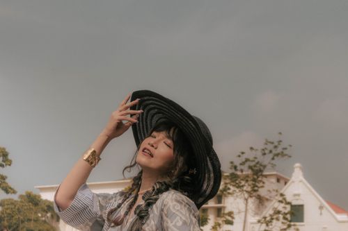 Free Stylish woman in a hat enjoying the sunlight outdoors. Perfect for fashion and lifestyle themes. Stock Photo