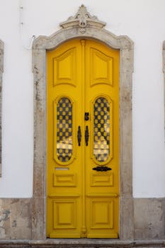 Charming yellow door showcasing Portuguese architecture in Olhão, ideal for travel and design inspiration.