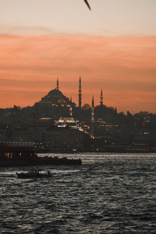 Free Beautiful sunset view over Istanbul with iconic skyline, featuring silhouettes of mosques and boats in the foreground. Stock Photo