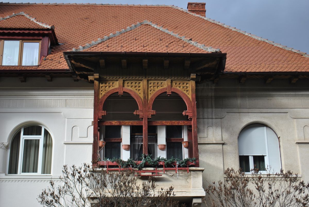 Balcon rustic din lemn sculptat pe o fatada istorica