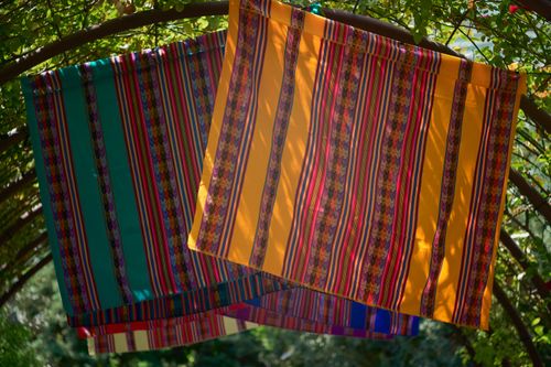 Free Brightly colored traditional textiles with striped patterns hanging outside under sunlight. Stock Photo